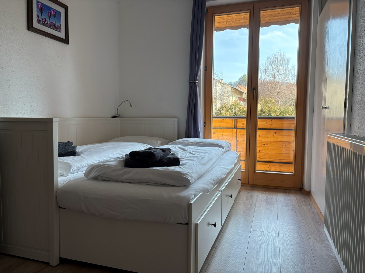 Afbeelding van Comfortable familiekamer met balkon en tuinzicht.