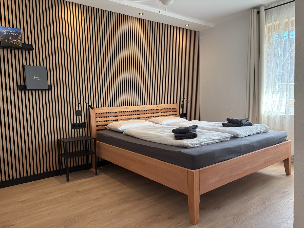 Afbeelding van Comfortable familiekamer met balkon en tuinzicht.