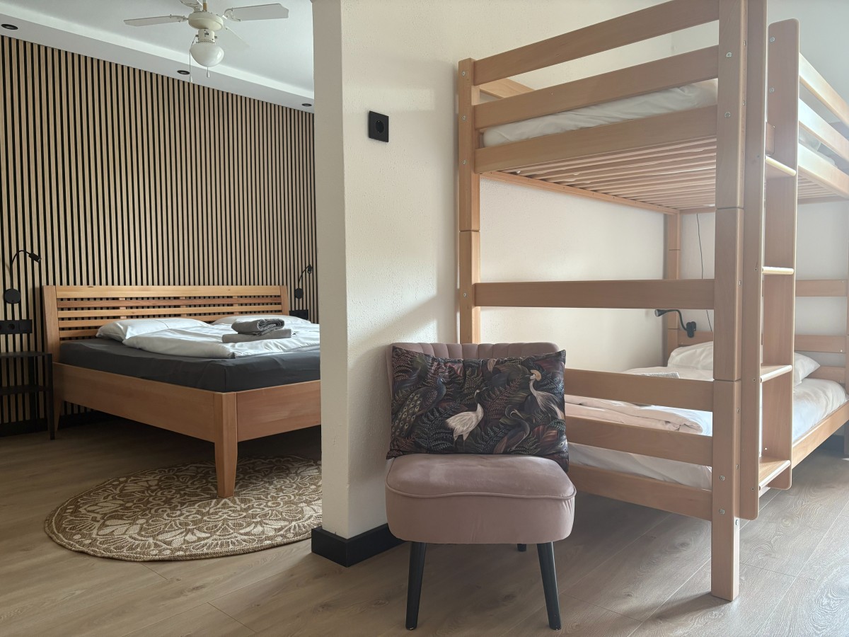 Afbeelding van Comfortable familiekamer met balkon en tuinzicht.